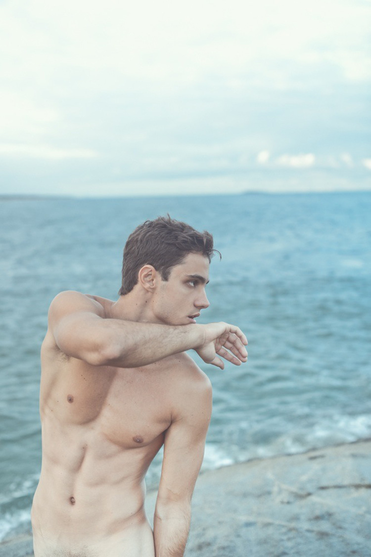 На фото красивый голый парень в пляжном домике